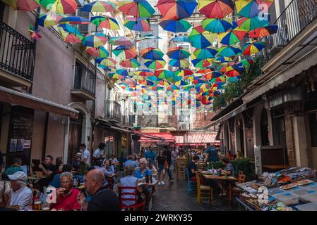 Colourful umbrellas above restaurants in area of food market and La Pescheria fish market on Old Town on Catania city, Sicily Island, Italy Stock Photo
