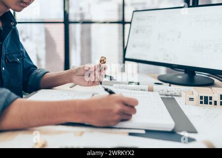 Architect engineer use pen  drawing design working on blueprint and holding joint pipe. House planning design and construction concept. Stock Photo