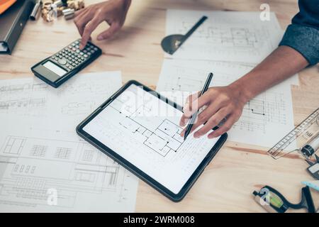 Architect engineer use tablet to read drawing design. House planning design and construction concept. Stock Photo
