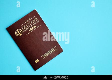 Red Islamic Republic of Iran passport on blue background close up. Tourism and citizenship concept Stock Photo