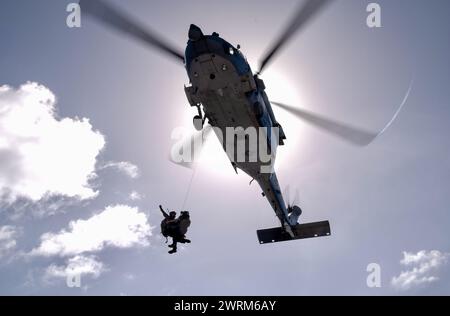 On March 6, 2024, the U.S. Coast Guard and U.S. Navy's Helicopter Sea Combat Squadron 25 (HSC-25) effectively evacuated a U.S. Coast Guard member Stock Photo