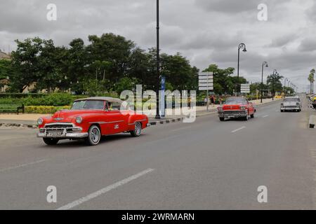 063 Red Chevrolets from 1952-56 and gray Buick from 1958 American classic cars -almendron, yank tank- on Avenida del Puerto-Port Avenue. Havana-Cuba. Stock Photo