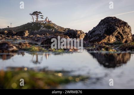Beautiful view of the Battery Point Lighthouse seen thru the rocks and puddles with reflections in Crescent City California. Stock Photo