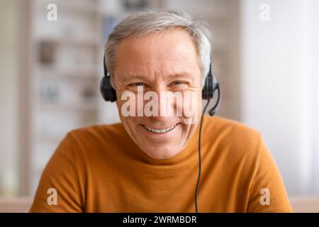 Closeup of senior man using headset smiling at camera Stock Photo