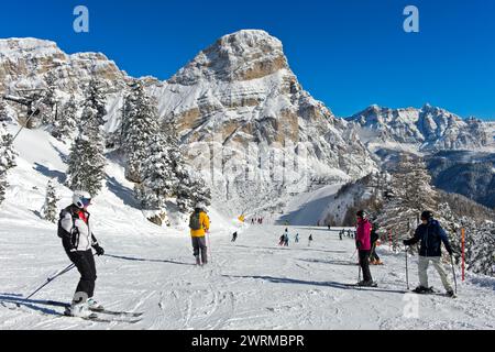 Skiers on a slope in the winter sports resort of Colfosco at the foot of the Sassongher peak in the Alta Badia ski area, Dolomite, South Tyrol, Italy Stock Photo