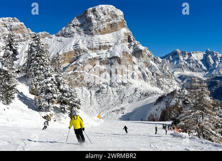 Skiers on a slope in the winter sports resort of Colfosco at the foot of the Sassongher peak in the Alta Badia ski area, Dolomite, South Tyrol, Italy Stock Photo