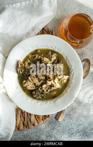 Top view of traditional Georgian dish of stewed meat cooked with white wine, tangy green plums, and a mix of fresh herbs including tarragon, coriander Stock Photo