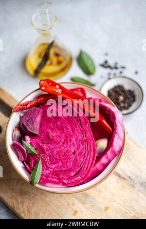 A bowl of vibrant fermented cabbage mixed with beetroot, spicy red pepper, and garlic, presented on a wooden surface. Stock Photo