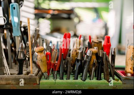 A collection of well-used shoemaking tools on a workstation in an Austrian shop, illustrating the shoemaker's craft. Stock Photo