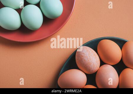 Top view two plates with pastel-colored Easter eggs denote a festive spring celebration. The soothing hues and minimalist composition evoke the joyful Stock Photo