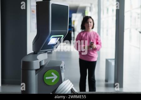 A modern automatic ticket reading machine stands at a science museum entrance, with a blur of a boy and girl in the background, indicating youth engag Stock Photo