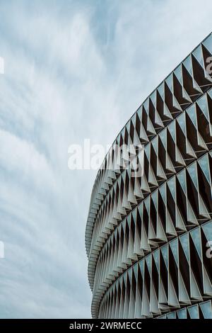 Geometric patterns of a modern facade set against a cloudy sky. Stock Photo