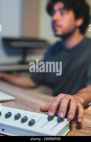 Music professional in concentrated work, fine-tuning an audio mixer during a sound studio session. Stock Photo