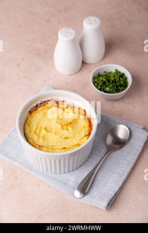 Shepherd's pie in a portioned white baking dish. Homemade traditional casserole (gratin) with minced meat and mashed potatoes. Selective focus, close- Stock Photo