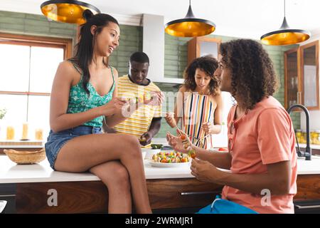 Diverse group of friends preparing food in a modern kitchen Stock Photo