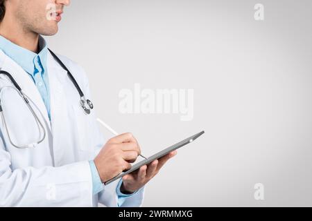 Focused man doctor using digital tablet, free space Stock Photo