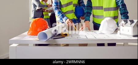 Professional builders discussing architect project at construction site Stock Photo