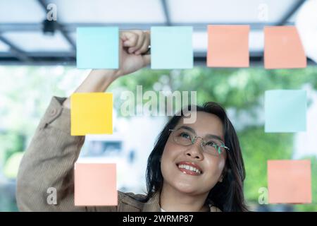 businesswoman is writing about business ideas on sticky note at the office Stock Photo