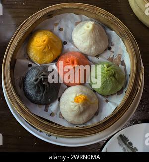 soup dumplings in a bamboo steam tray (Xiaolongbao, xiao long bao) pork, chicken, colorful dough multicolored from Shanghai Stock Photo