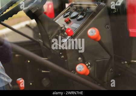 A close-up view highlighting the control levers inside the cabin of a tractor, showcasing the details of agricultural machinery. Stock Photo