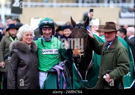 Trainer Willie Mullins, wife Jackie Mullins and jockey Patrick Mullins pose for a photo with Jasmin De Vaux as they celebrate winning the Weatherbys Champion Bumper on day two of the 2024 Cheltenham Festival at Cheltenham Racecourse. Willie Mullins reached the magical 100-winner mark at the Cheltenham Festival as the Patrick Mullins-ridden Jasmin De Vaux provided him with a 13th victory in the Weatherbys Champion Bumper. Picture date: Wednesday March 13, 2024. Stock Photo