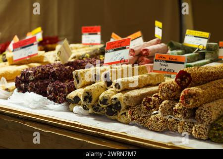 A variety of Turkish delights, featuring different flavors and nuts, are neatly arranged on a market stall, ready for customers to purchase. Stock Photo