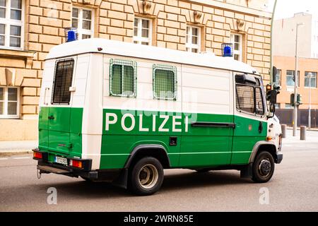 white and green police bus parked on street in Berlin, symbol law and order, emergency response, international cooperation in maintaining National sec Stock Photo