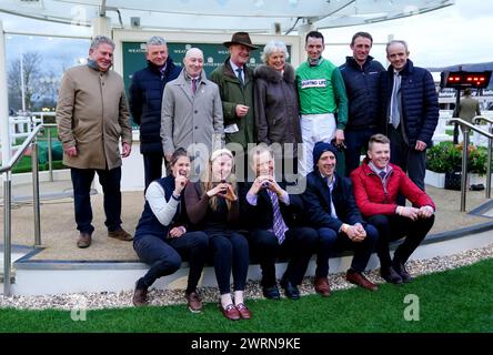 Trainer Willie Mullins, wife Jackie Mullins, jockey Patrick Mullins, Ruby Walsh and their connections pose for a photo as they celebrate after Jasmin De Vaux wins the Weatherbys Champion Bumper on day two of the 2024 Cheltenham Festival at Cheltenham Racecourse. Willie Mullins reached the magical 100-winner mark at the Cheltenham Festival as the Patrick Mullins-ridden Jasmin De Vaux provided him with a 13th victory in the Weatherbys Champion Bumper. Picture date: Wednesday March 13, 2024. Stock Photo