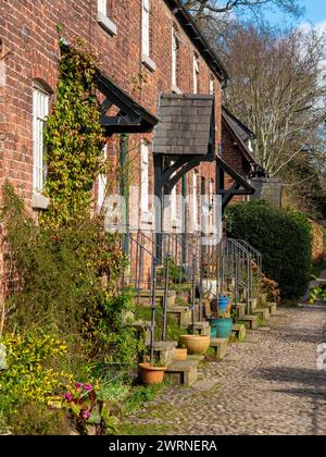 Row of traditional cottages along a cobbled lane in the village of Styal. Wilmslow, Cheshire, UK Stock Photo