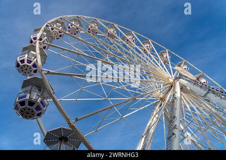 Southampton, England - December 8, 2023: Ferris wheel ride with gondolas in front of a blue sky in Southampton, England *** Riesenrad Fahrgeschäft mit Gondeln vor blauem Himmel in Southampton, England Stock Photo