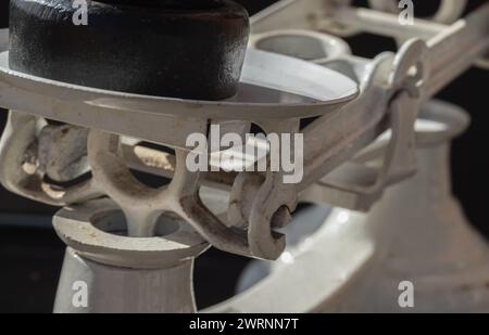 Close-up of Classic weight scale Isolated on dark background. Detail of Old obsolete manual weighing scales with set of cast iron weights. Antique bal Stock Photo