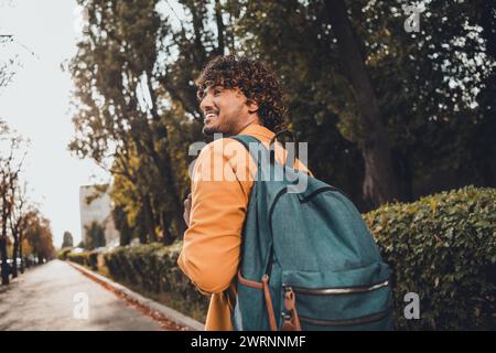 Photo of positive nice young hispanic man with backpack exploring city streets vacation trip travel pastime promenade outside Stock Photo
