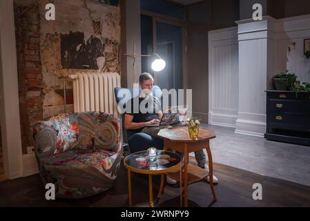 Person Working on Laptop in Stylish Room with Rustic, Modern Decor Stock Photo