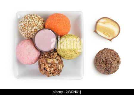 A variety of different truffles in a ceramic bowl Isolated on a white background. Top view. Flat lay Stock Photo