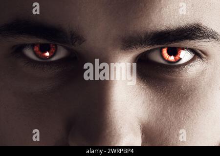 Evil eye. Man with red demonic eyes, closeup Stock Photo
