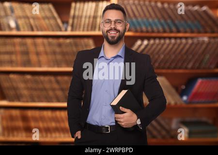 Successful lawyer in glasses against shelves with books Stock Photo