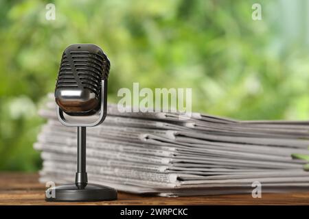 Newspapers and vintage microphone on table. Journalist's work Stock Photo