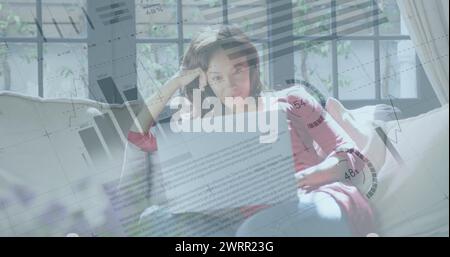 Image of financial data processing over woman using laptop at home Stock Photo