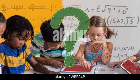 Image of green question mark and maths equations over diverse primary school class Stock Photo