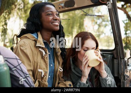 Happy women, tea or relax on road trip in nature or travel adventure for leisure in countryside. Ladies, drinking and coffee in suv on summer holiday Stock Photo