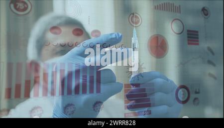 Image of digital interface showing statistics with masked male doctor preparing vaccine syringe Stock Photo