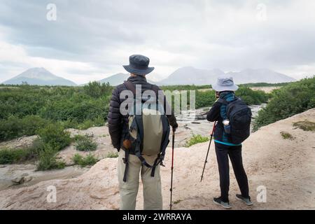 Two people hiking the Valley of Ten Thousand Smokes. Taking photos using smartphone. Katmai National Park and Preserve. Alaska. USA. Stock Photo