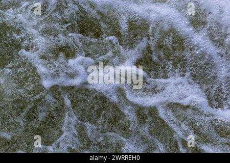 Close up detail of fierce white water river rapids from a clean deep green colored river forming a textured background. Stock Photo