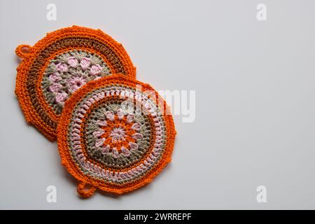 two handmade croketing pot holders in pink and orange color, isolated on white Stock Photo