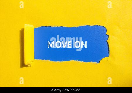 Move on words written on yellow torn paper with blue background. Conceptual symbol. Copy space. Stock Photo