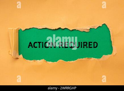 Action required words written on orange torn paper with green background. Conceptual symbol. Copy space. Stock Photo