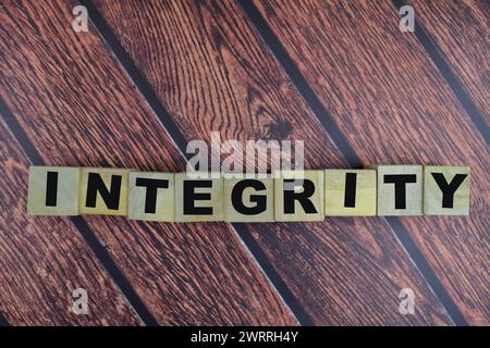 Concept of The wooden Cubes with the word Integrity on wooden background. Stock Photo
