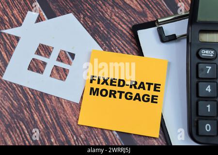 Concept of Fixed-Rate Mortgage write on sticky notes isolated on Wooden Table. Stock Photo