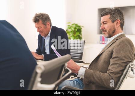 Senior executives engaged in a focused business strategy meeting, highlighting teamwork and corporate leadership. Stock Photo