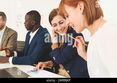 Group of diverse business team discussing project plans in office setting - cooperation and strategy Stock Photo
